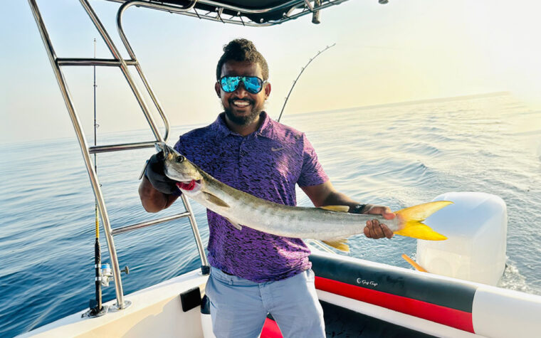 Angler holding a queenfish caught on a Sea King deep sea fishing trip off Dubai