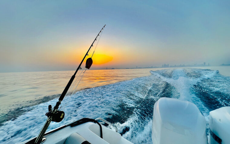 Trolling rod set in the holder as the sun rises over the Arabian Gulf