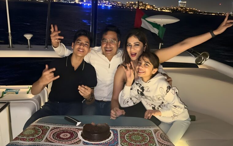 Family celebrating around a cake on the deck of the private yacht